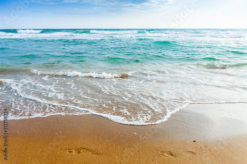 Girl sitting on a sandy beach and looking at a dark blue Mediterranean sea. © Oleg