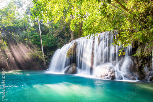 Fototapeta Naklejka Na Ścianę i Meble -  Waterfall and blue emerald water color in Erawan national park with sun light and light ray sunflare, Beautiful nature rock waterfall steps in tropical rainforest at Kanchanaburi province, Thailand