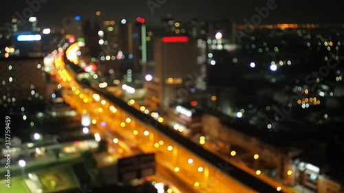 Defocused night city traffic road lights in Bangkok with transportation MRT Metro Rail Transit and car driving.