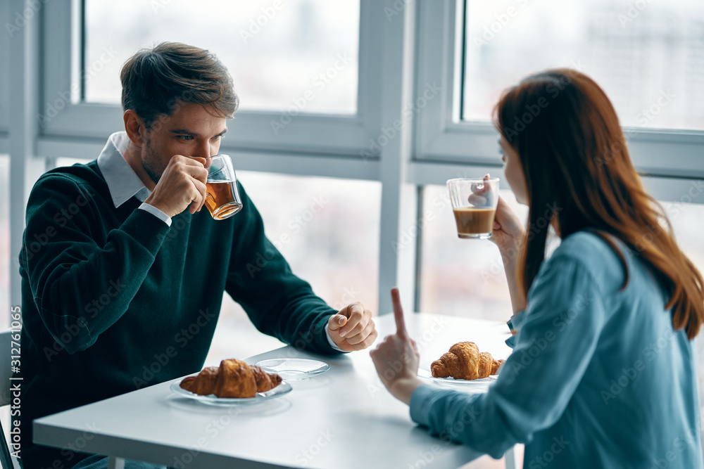 man and woman talking on the phone in cafe man and woman talking on the phone in cafe