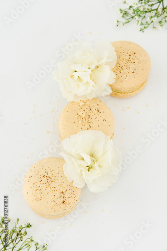 French sweet vanilla macarons cookies on white wooden table . Dessert