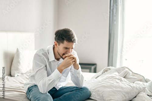 man sitting on sofa and talking on cell phone