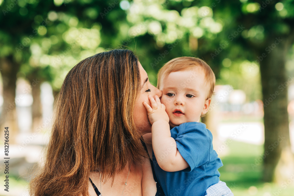Outdoor portrait of happy mother holding adorable baby boy in arms Outdoor portrait of happy mother holding adorable baby boy in arms