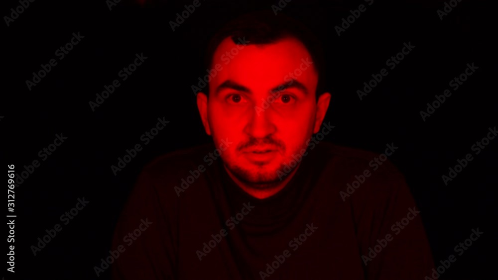 Man Face in Dark, with Red Glowing Light, Facial Expressions. Portrait
