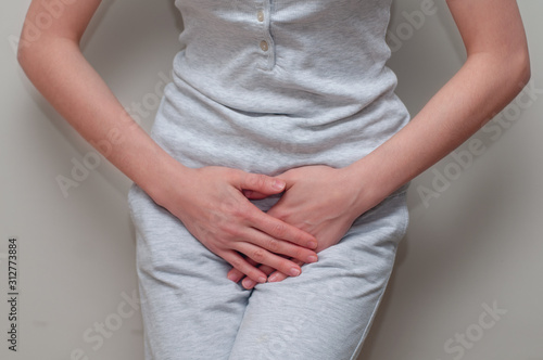 Woman with urinal or bladder infection, hands over crotch