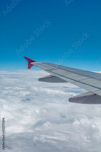 Look through the plane window and white cloud and blue sky
