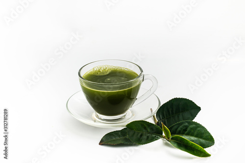 Hot fresh Green Tea drink in through white glass cup and dish. Place with deep green tea leaves.