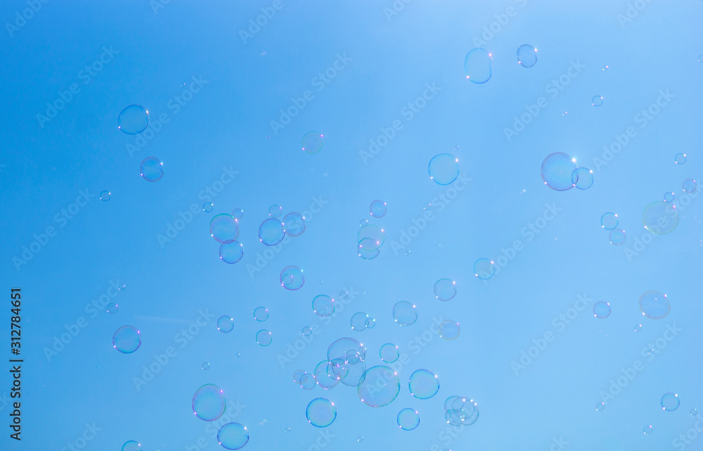 Background with soap bubbles on bright blue sky