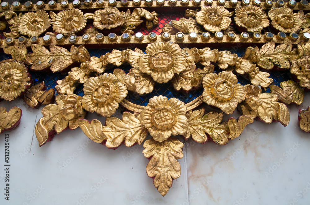 Traditional wood carving with ancient flower patterns decorating with gold mirror, Thailand Traditional wood carving with ancient flower patterns decorating with gold mirror, Thailand