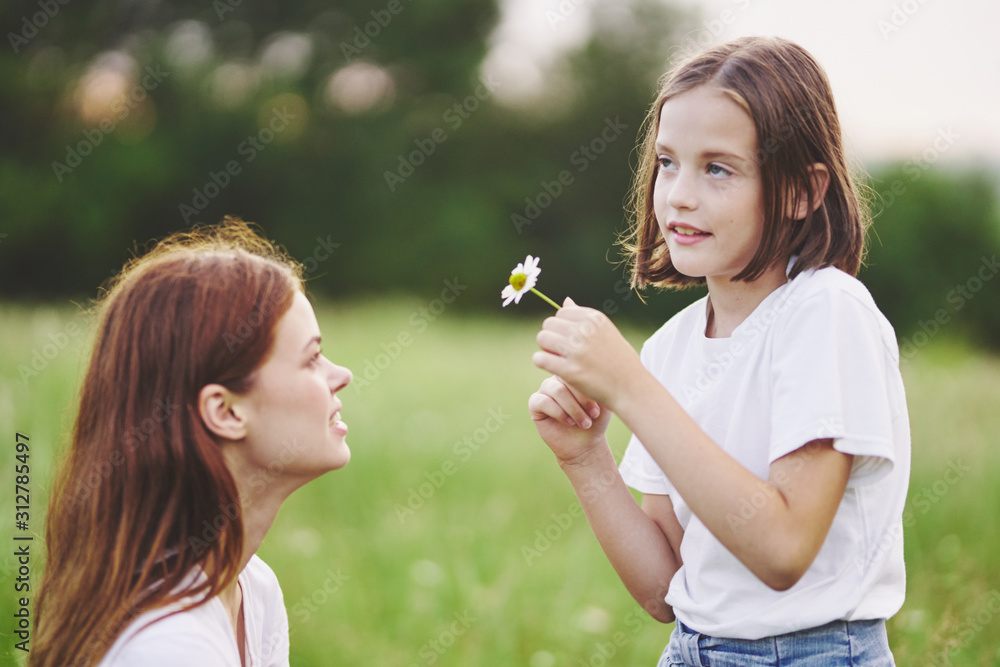 mother and daughter blowing soap bubbles in the park mother and daughter blowing soap bubbles in the park