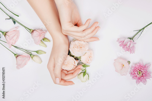 Beautiful stylish trendy female pink manicure with flower on background, top view. Concept bio nature cosmetics skin care