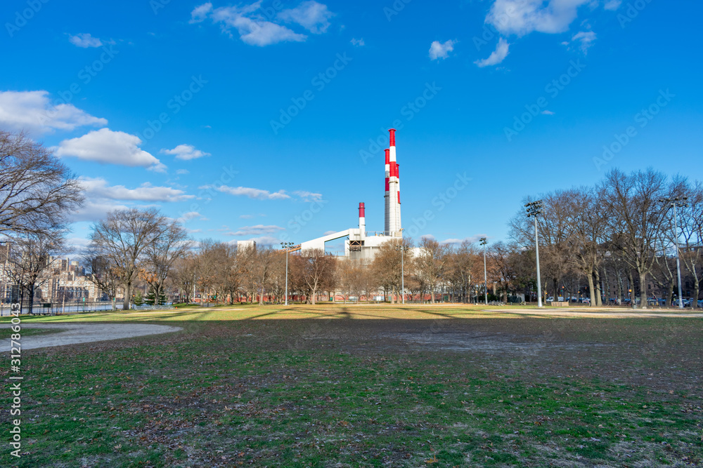 Obraz premium Queensbridge Park in Long Island City Queens New York with Open Space and Smoke Stacks from a Power Plant
