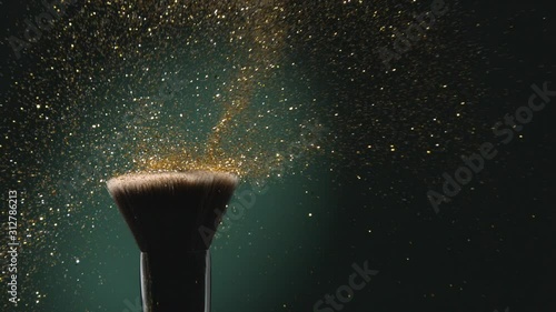Glitter on a Make-up Brush Flying Away with Woman Finger Flicking Shot in Slow Motion on Green Aqua Menthe Color Background