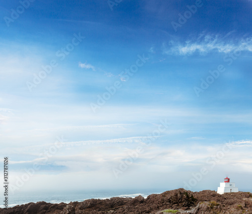 Kleiner Leuchtturm vor blauem Himmel