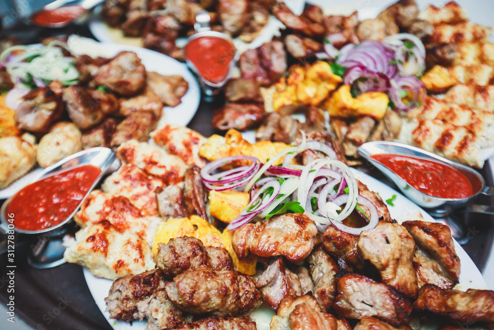 Variety assortment of traditional main course meat barbecue grill dishes of Caucasian cuisine, with shashlik on skewer, Lyulya kebab, kebab, Azerbaijani cuisine