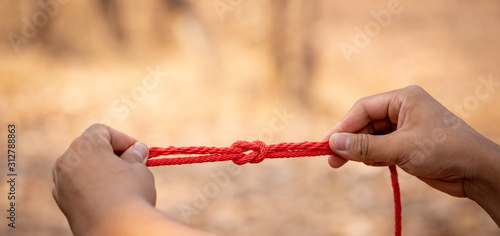 Scout learning concept, scout knot learning in forest in camping of boy scout on hills. Education teacher teaching tie knot for children in boy camp on hills