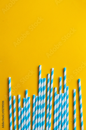 Blue cocktail straws on a yellow background