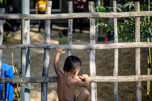 rohingya refugee children playing on the fence of refugee camp in teknaf bangladesh photo