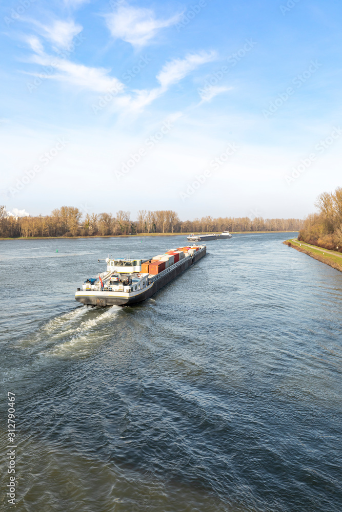 Fototapeta premium Binnenschiff mit Container beladen auf dem Rhein