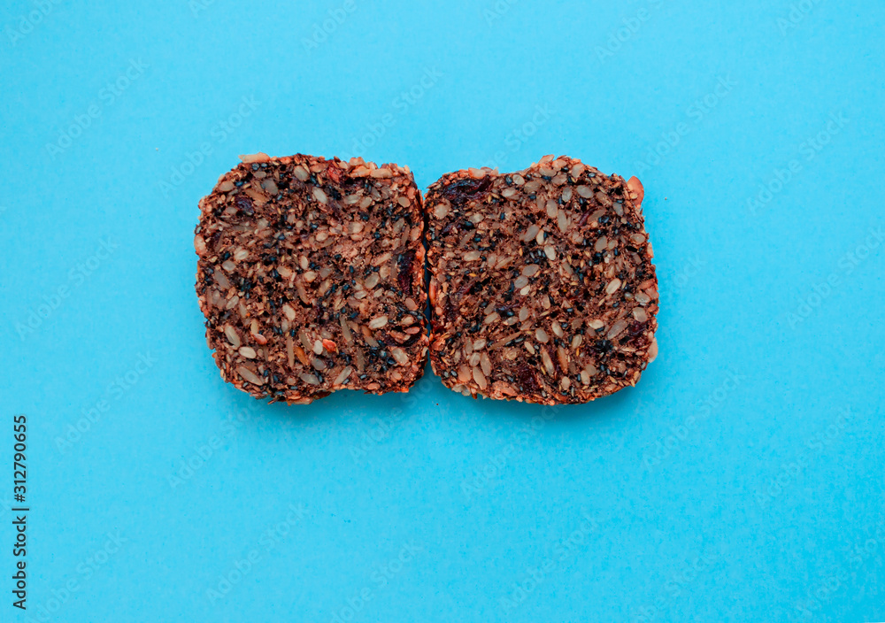 Sliced whole grain bread rye with seeds flax, sunflower, pumpkin and sesame.Healthy food, eco-friendly natural products. Fresh bread on a blue background. Sliced whole grain bread rye with seeds flax, sunflower, pumpkin and sesame.Healthy food, eco-friendly natural products. Fresh bread on a blue background.