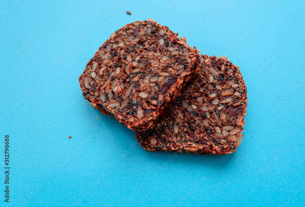 Sliced whole grain bread rye with seeds flax, sunflower, pumpkin and sesame.Healthy food, eco-friendly natural products. Fresh bread on a blue background. Sliced whole grain bread rye with seeds flax, sunflower, pumpkin and sesame.Healthy food, eco-friendly natural products. Fresh bread on a blue background.