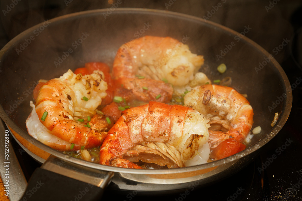 King prawns in a pan with tomatos and herbs