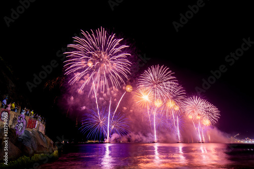 Spectacular fireworks display above water in Copacabana beach, celebrating New Year