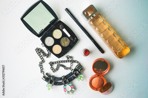 UK, Hove, 7/12/2019: Layout of perfume Boss, eyeshadows and blush, a necklace in black with bright stones, and red MAC lipstick