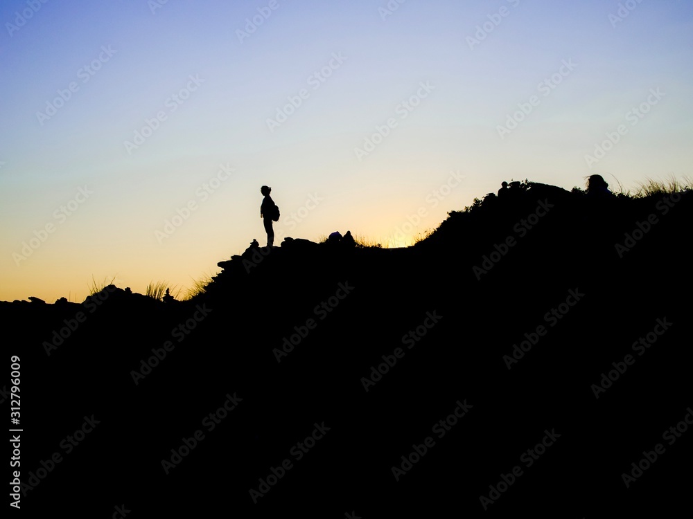 silhouette of man on top of mountain