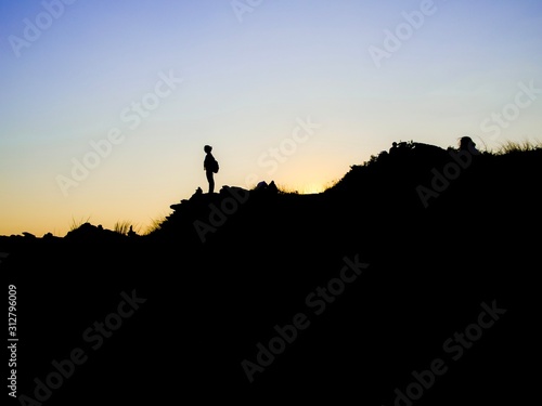 silhouette of man on top of mountain © Sittichoke
