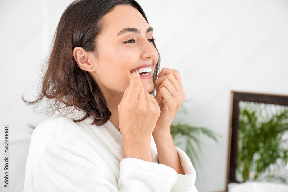 Beautiful young woman with dental floss in bathroom Beautiful young woman with dental floss in bathroom