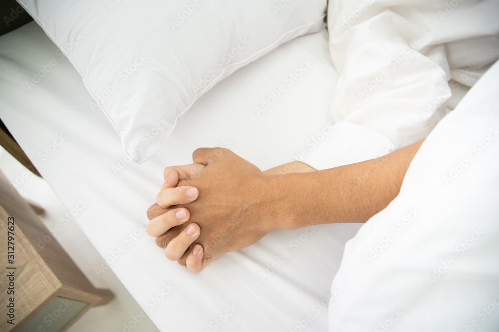 Close up on the Asian couple's hands during they having a sex on the bed.