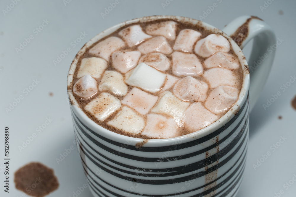 Selective focus close up shot of hot chocolate drink with white marshmallows in black and white mug isolated on white. Selective focus close up shot of hot chocolate drink with white marshmallows in black and white mug isolated on white.