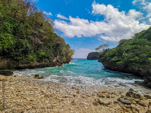 Fototapeta Naklejka Na Ścianę i Meble -  Secret Rocky Beach With Bright Turquoise Water Hidden In A Valley Named Bulian Beach In Nusa Penida, Bali, Indonesia