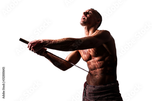 A man with a katana, in blood, makes hara-kiri. Isolated on a white background. photo