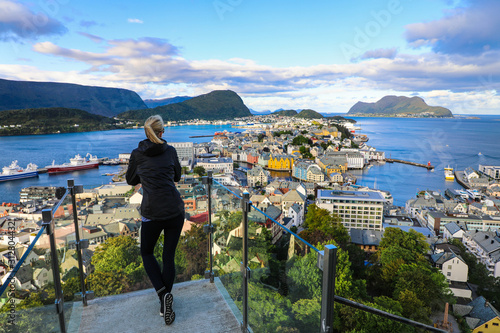 Blond woman enjoying aerial view of the colorful town of Alesund Norway photo