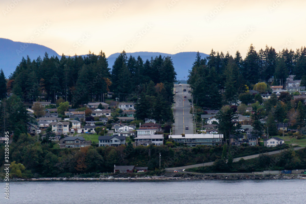 Campbell River, Vancouver Island, British Columbia, Canada. Beautiful view of residential homes on the ocean shore during a cloudy evening.