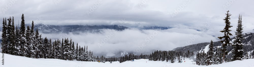 Whistler, British Columbia, Canada. Beautiful Panoramic View of the Canadian Snow Covered Mountain Landscape during a cloudy and foggy winter day. Whistler, British Columbia, Canada. Beautiful Panoramic View of the Canadian Snow Covered Mountain Landscape during a cloudy and foggy winter day.
