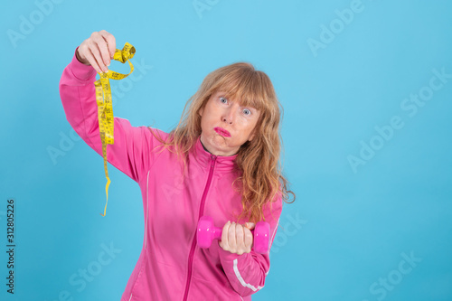 adult woman with sportswear isolated on color background with measuring tape, concept of diet and exercise of healthy life © carballo