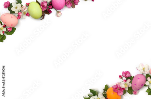 Easter decoration. Easter frame of pink flowers apple tree and colored easter eggs on white background with space for text. Top view, flat lay