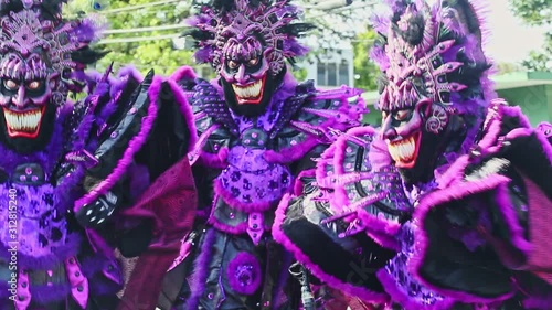 people in violet demon costumes dance at traditional dominican carnival annual event photo