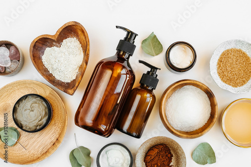 Beauty treatment ingredients for making homemade skin care cosmetic mask. Various bowl with clay, cream, essential oil and natural ingredients  on white table background. Organic spa cosmetic products photo
