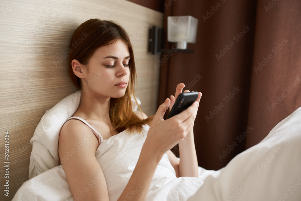 woman using mobile phone in bed woman using mobile phone in bed
