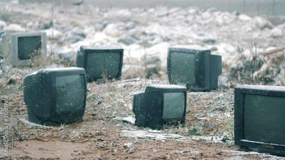 Snow is falling on switched-off TVs at the garbage site Snow is falling on switched-off TVs at the garbage site