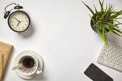 Flat lay on workspace with laptop computer, alarm clock and black coffee. With copy space, background, top view.