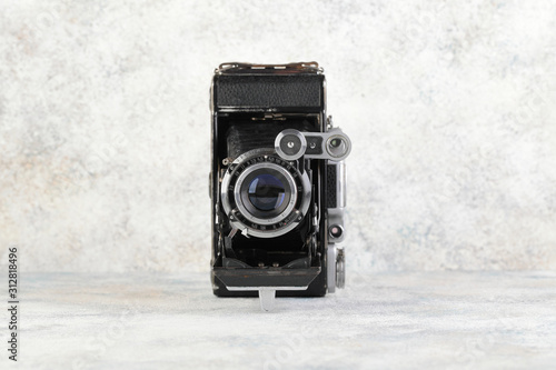 Photography Old medium format rangefinder camera on gray cement background.