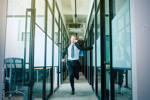 Businessman rushing and running on office hallway