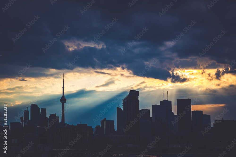 A high-contrast view of the Toronto skyline with a dramatic sky covered in clouds, Toronto, Ontario, Canada