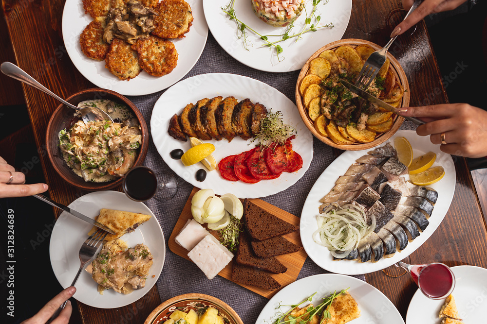 large wooden table with mouthwatering national Russian dishes. The restaurant where the food is cooked is as satisfying and delicious as home, top view