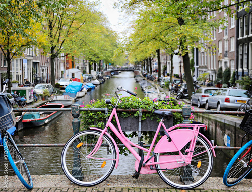 Pink bike on a bridge with the canal in Amsterdam. 